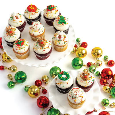 Decorative arrangement of cupcakes and Christmas ornaments on a white background
